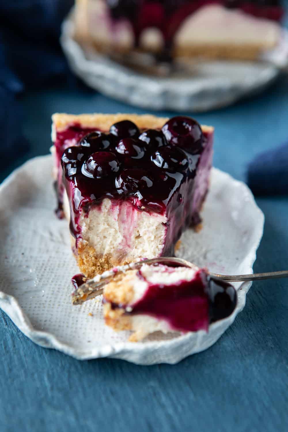 Slice of Baked Vegan Blueberry Cheesecake with a junk taken out