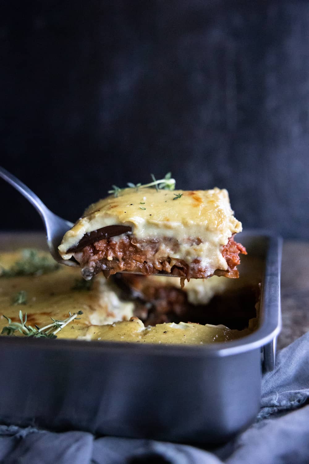 Vegan Moussaka lifting a piece out of the baking tray.