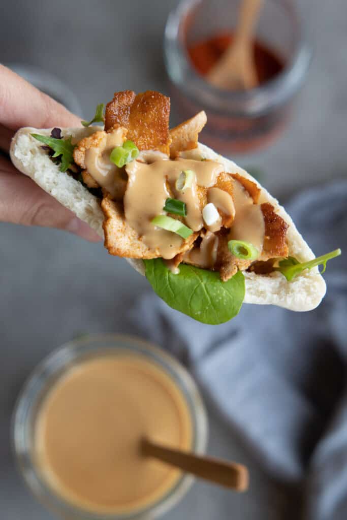 Peanut sauce on top of crispy tofu in a pocket close up.