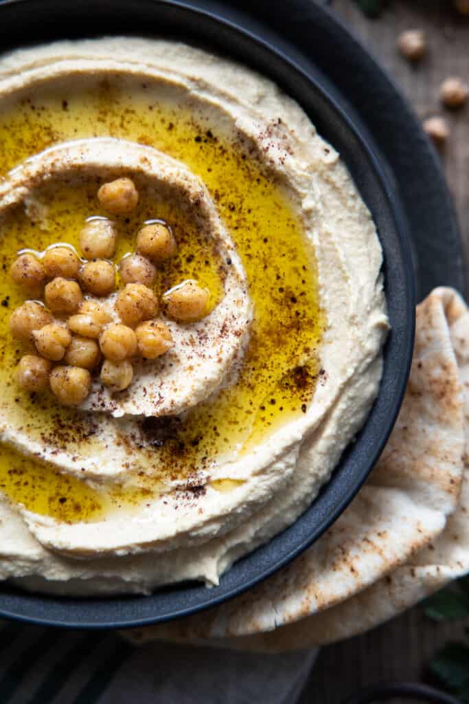 close up of hummus grom above with chickpeas and oil.