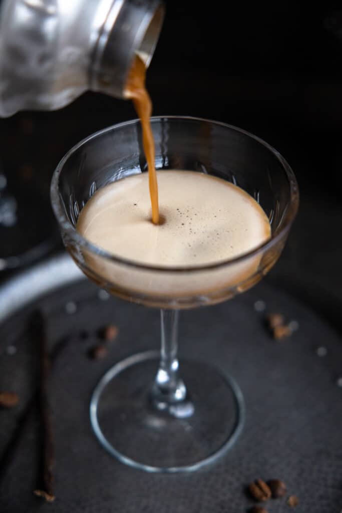 A vanilla espresso martini being poured into a glass.
