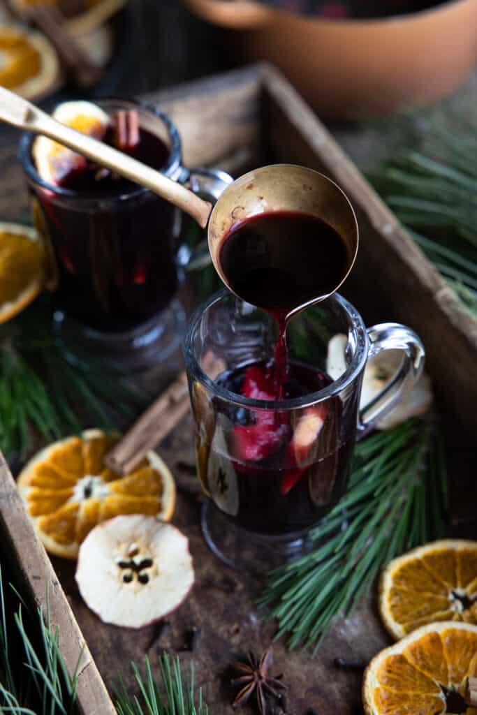 Mulled wine being ladled into glasses.