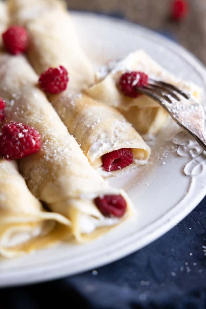 Crepes close up with coconut cream and raspberries.