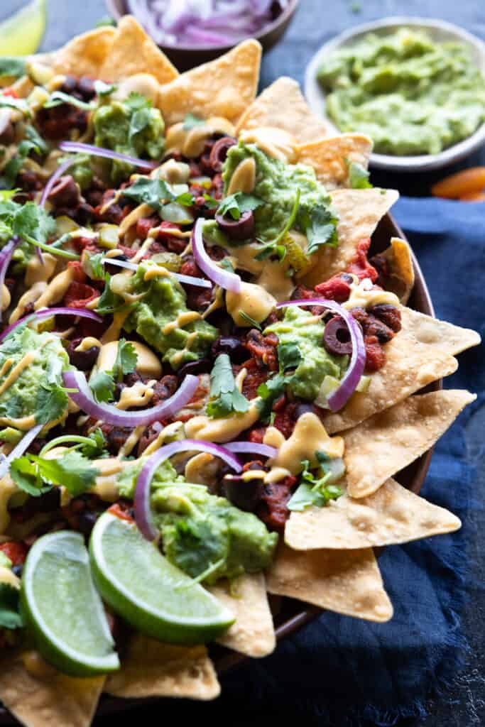 Veggie loaded nachos with all the toppings close up from an angle.