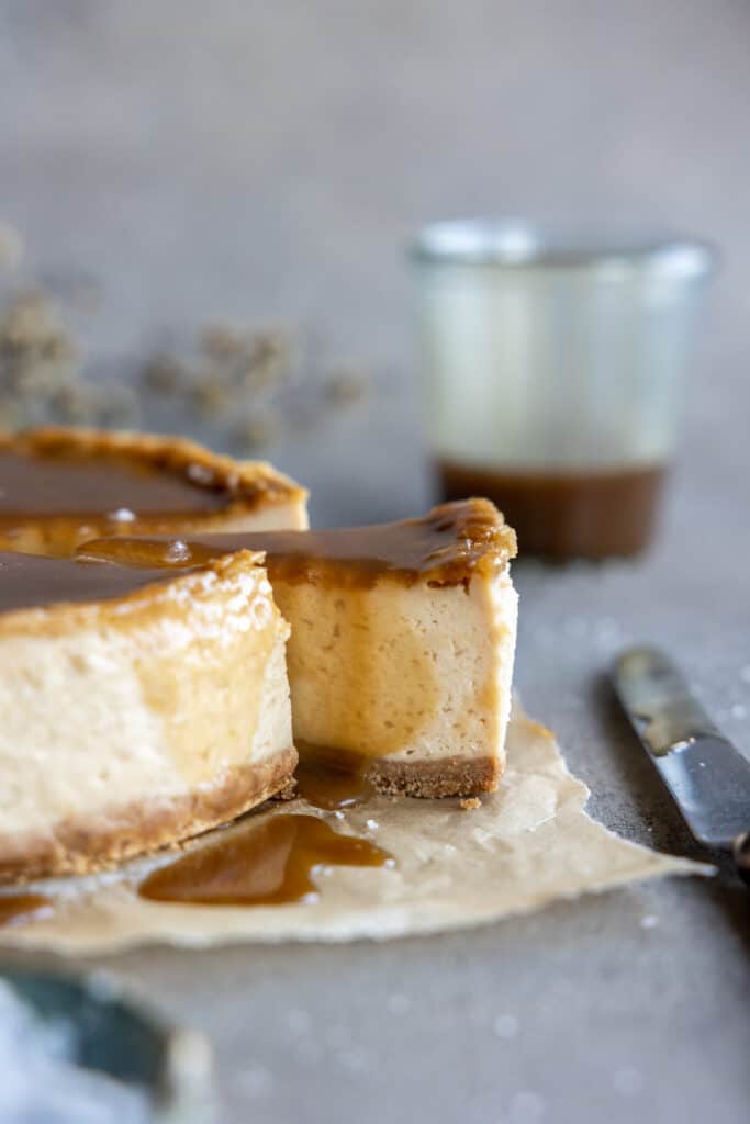 A cut slice being pulled out of the Vegan Salted Caramel Cheesecake.
