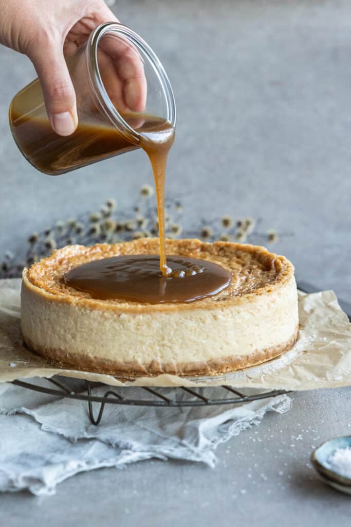 Pouring salted caramel over the Vegan Cheesecake.