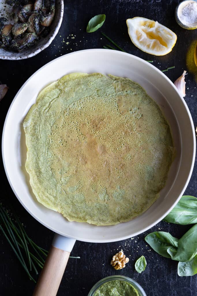 vegan spinach crepe in a frying pan.