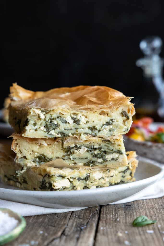 Vegan Spinach Pie with 'Ricotta' stacked on a plate with three pieces close up.