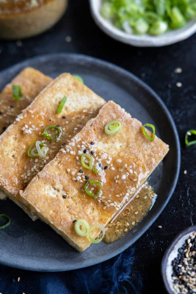 Sesame Miso Dressing drizzled onto pan-fried tofu.