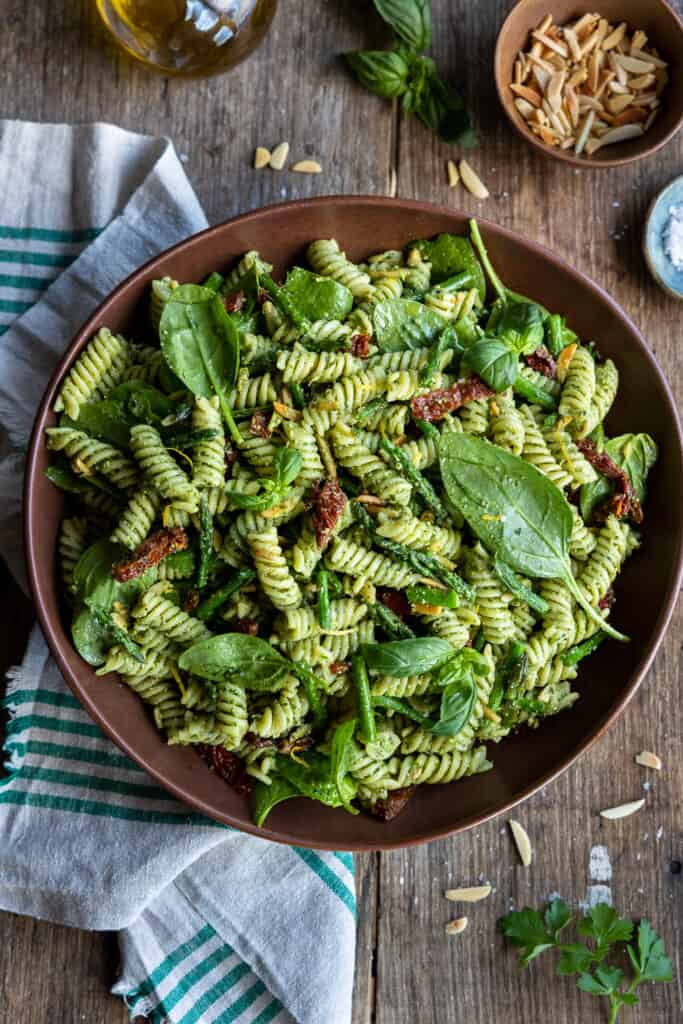 A large bowl of Vegan Pesto Pasta Salad with Sun-Dried Tomatoes