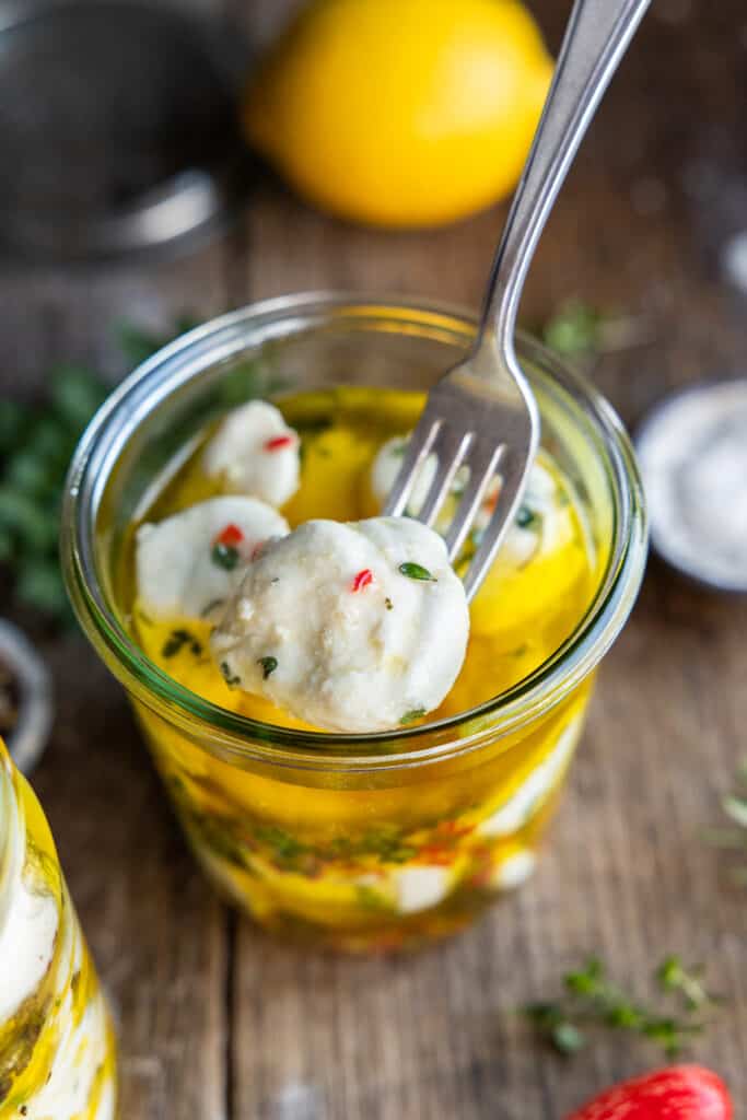 Marinated Vegan Bocconcini in a jar with fork.