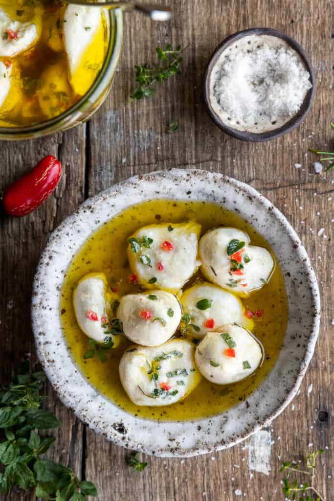 Marinated Vegan Bocconcini in herbs and oil in a small bowl.