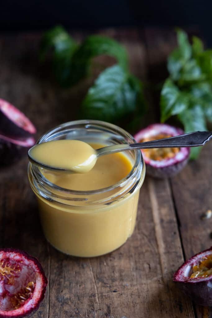 Eggless passionfruit curd on a spoon, showing the consistency. 