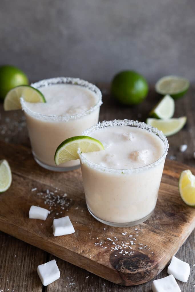 Creamy Coconut, Lime & Lychee Mocktail close up in coconut rimmed glasses.