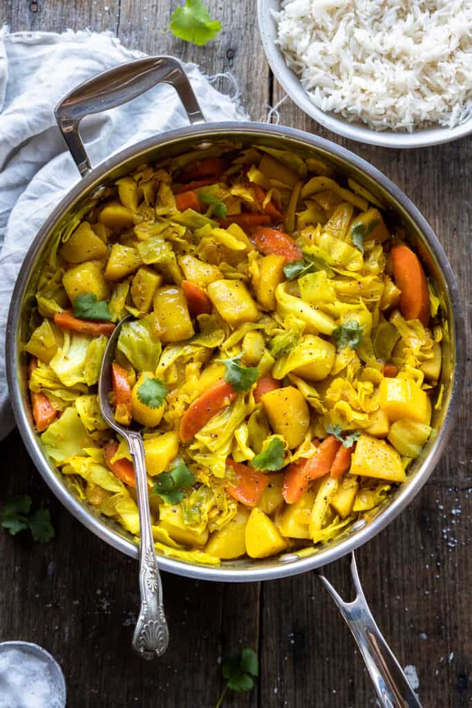 Tikil gomen (aka cabbage and potatoes) in a large skillet.